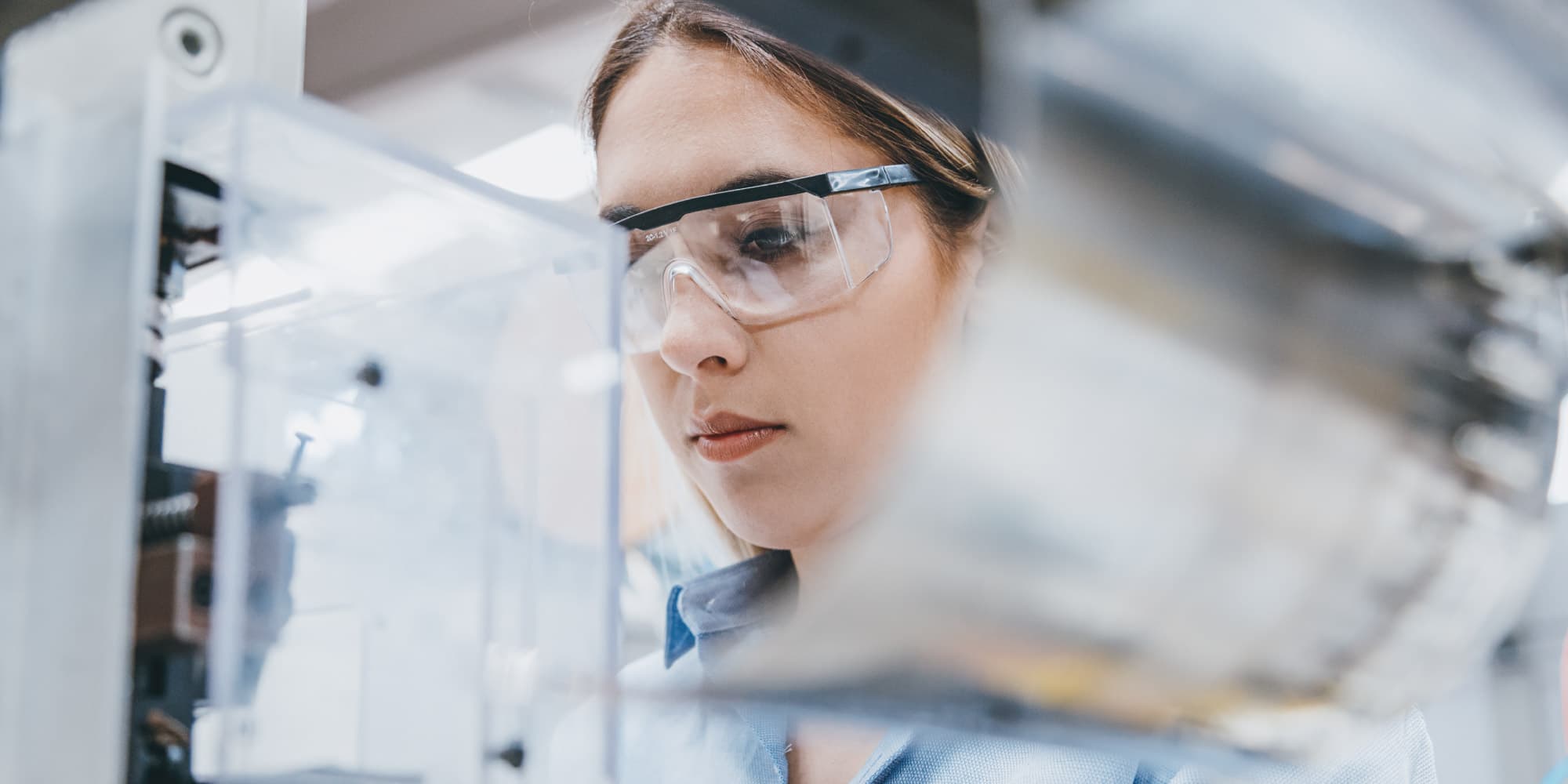 Innovatiediensten Onderzoeker met een veiligheidsbril die apparatuur in een laboratorium onderzoekt
