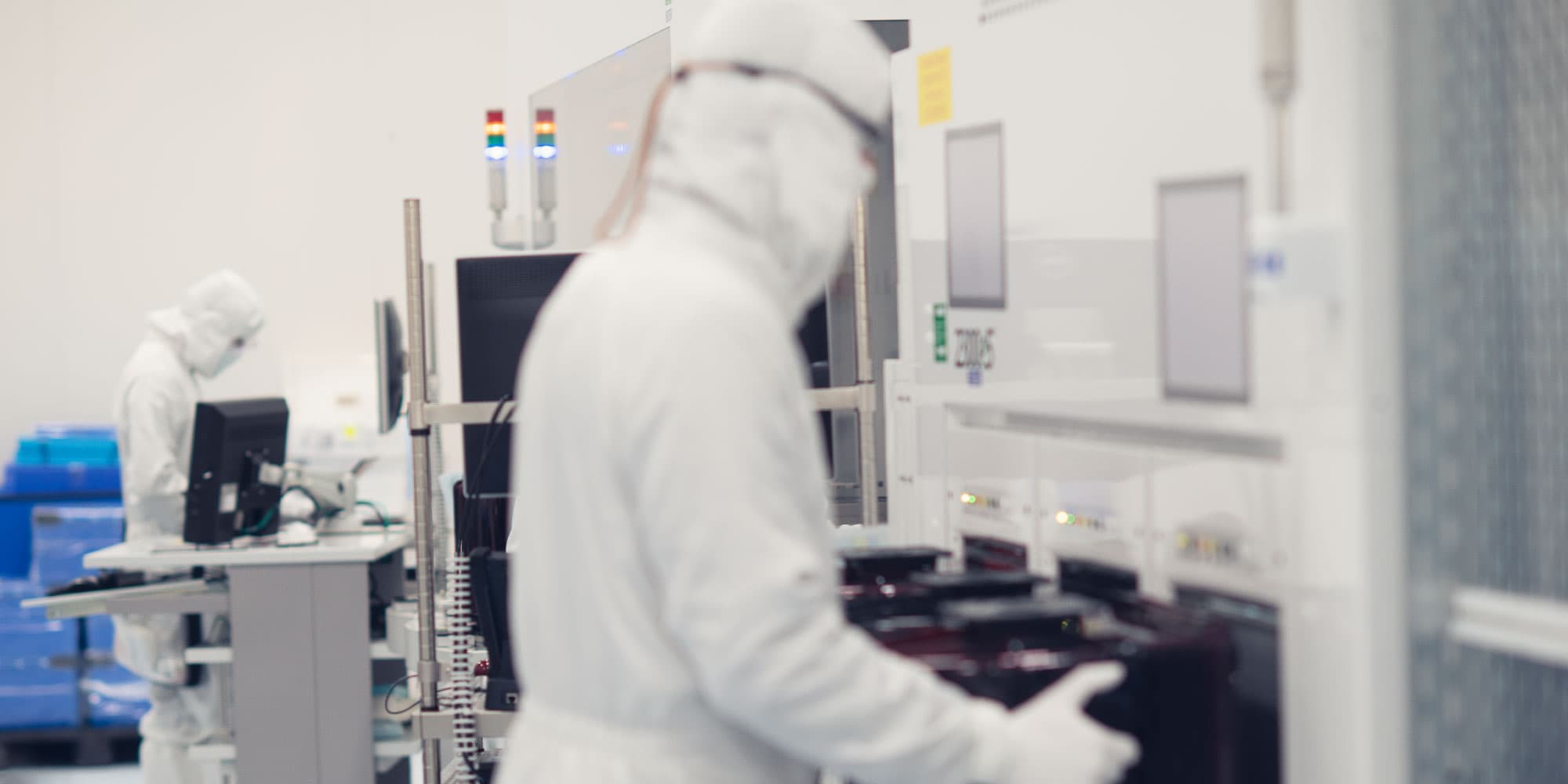 Wereldwijde-R%26D-hub Onderzoekers in cleanroomkleding werken met halfgeleiderapparatuur in een laboratorium