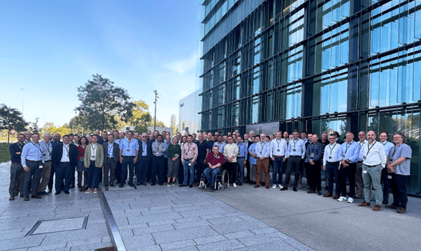 2nd%20automotive%20chiplet%20conference Group of conference attendees posing outside a modern glass building