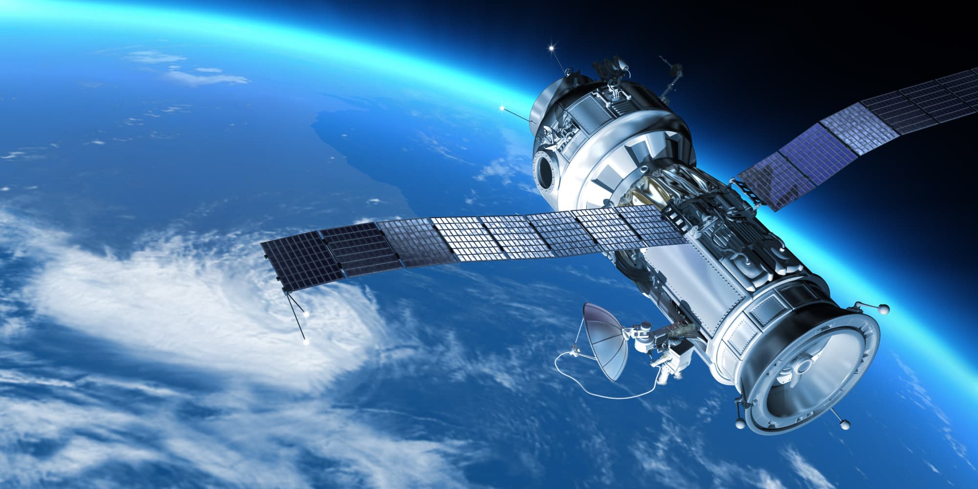 Earth-observation Satellite with long solar panels orbiting Earth above cloud cover