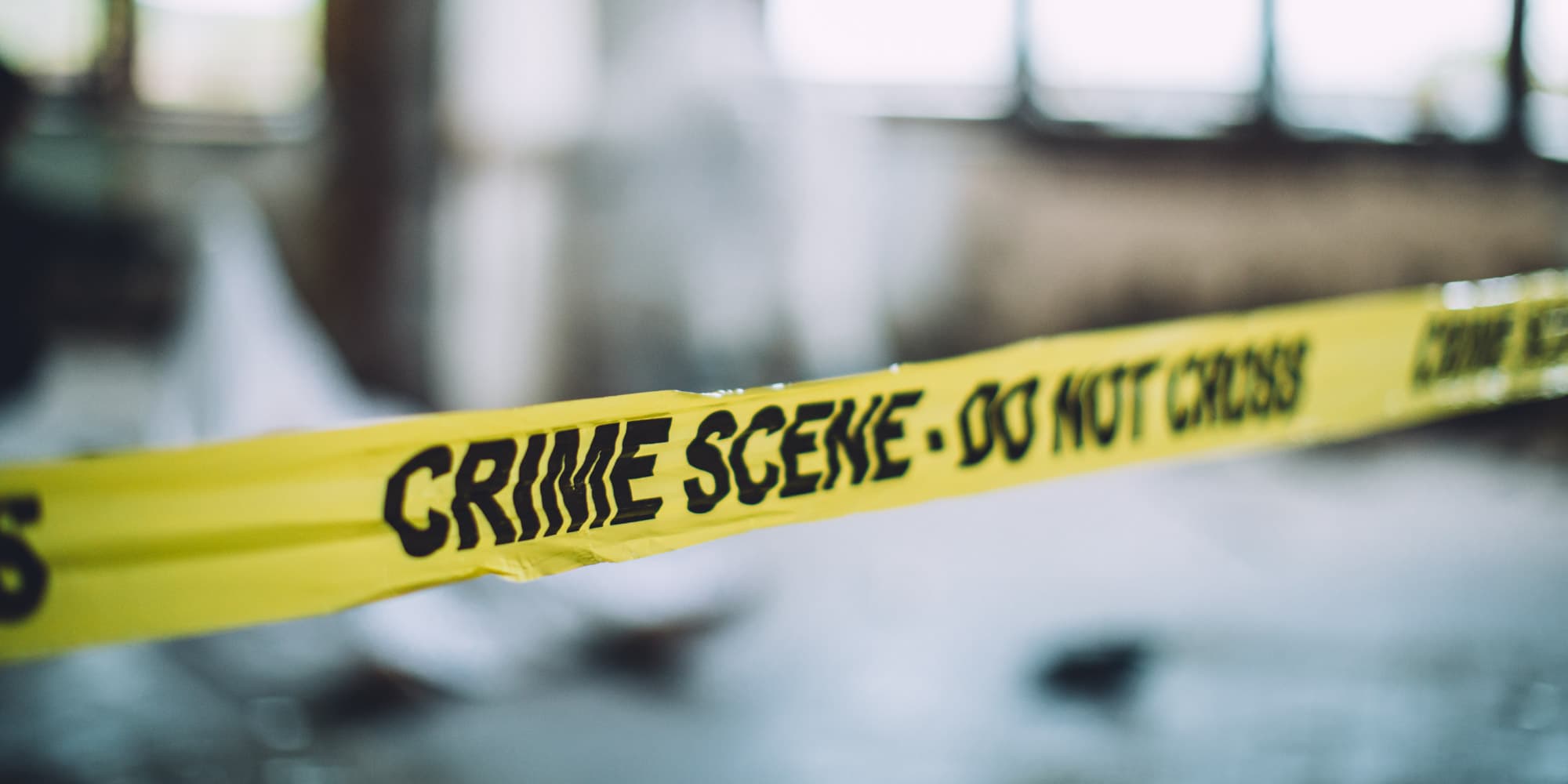 forensics_0 Yellow crime scene tape stretched across a blurred background