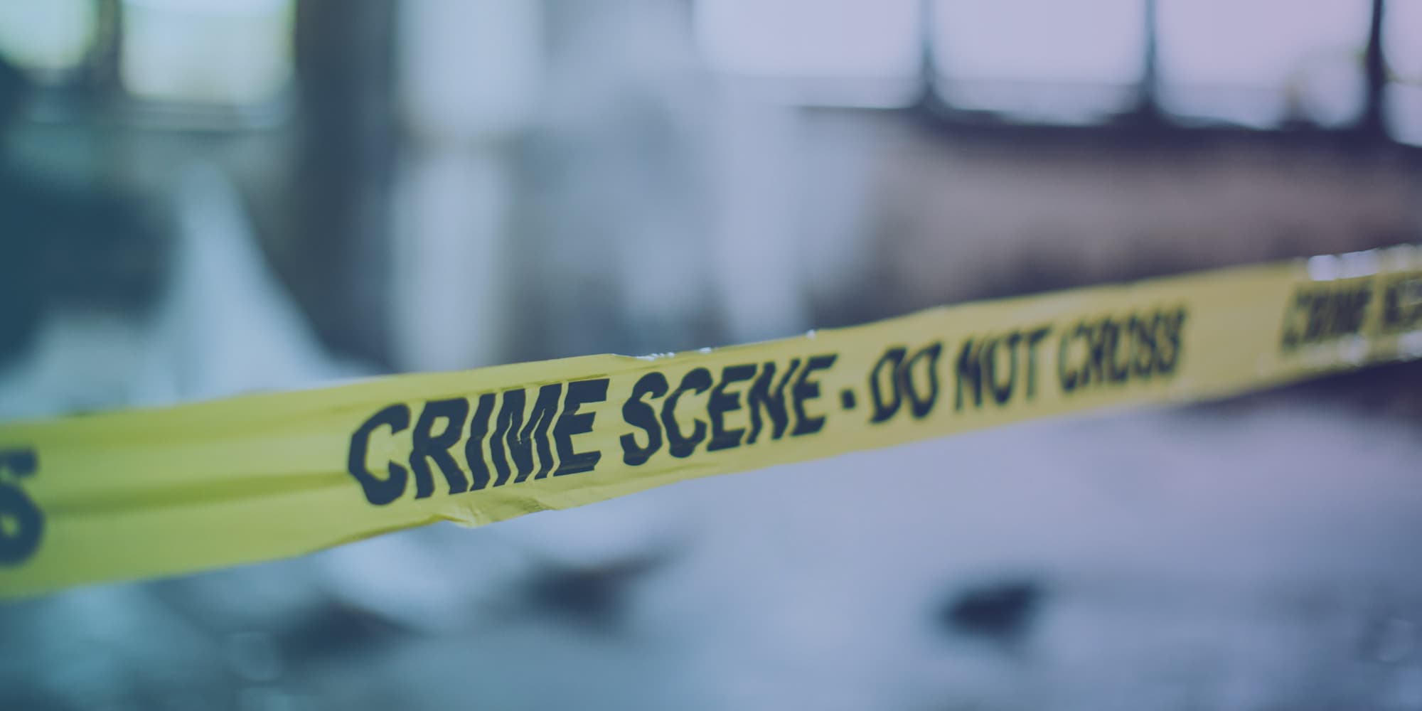 forensics Yellow crime scene tape stretched across a blurred background