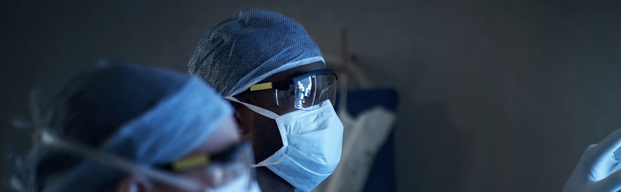 Surgical%20imaging%20banner Masked surgeon wearing protective goggles in an operating room