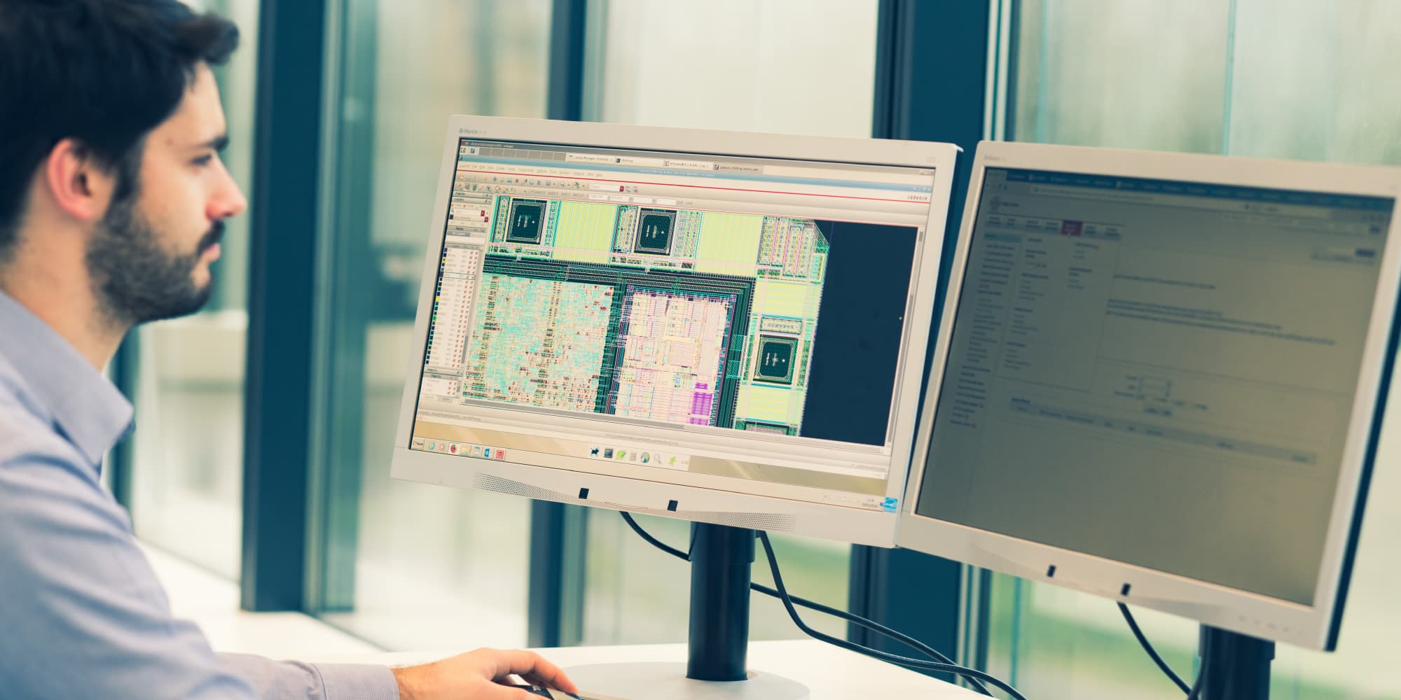 ASIC-services Engineer reviewing chip design layout on dual monitors
