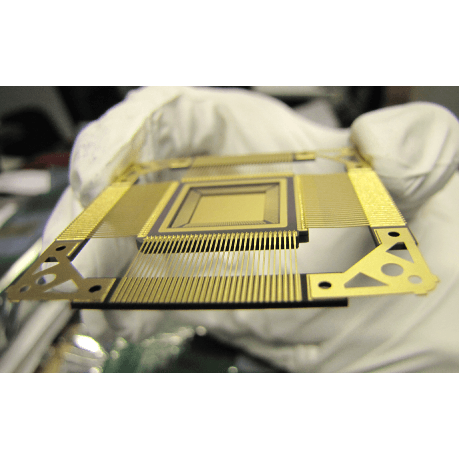 Assembly-and-advanced-package-design-services Gloved hands holding a semiconductor package with fine gold bonding wires