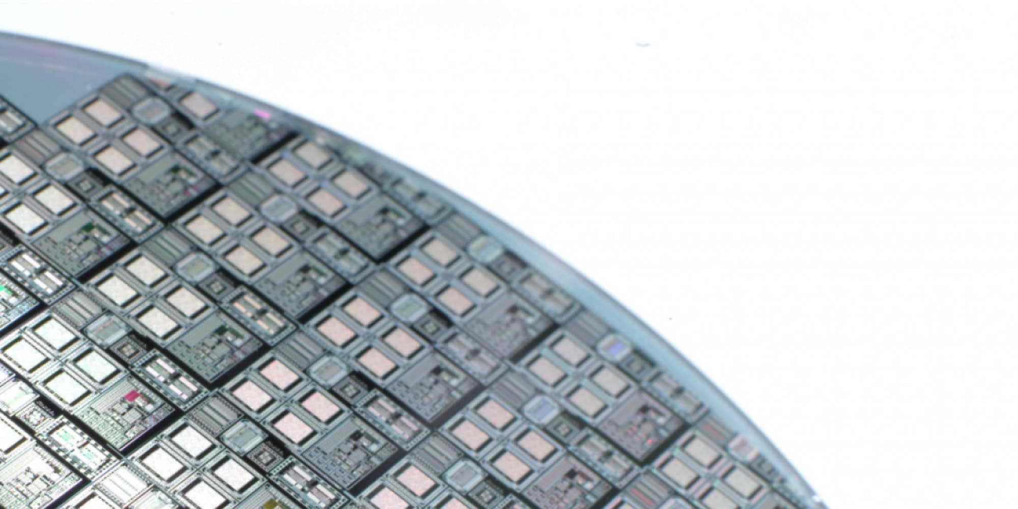 imec-ic-link-careers Close-up of a semiconductor wafer with many chip patterns on a bright background