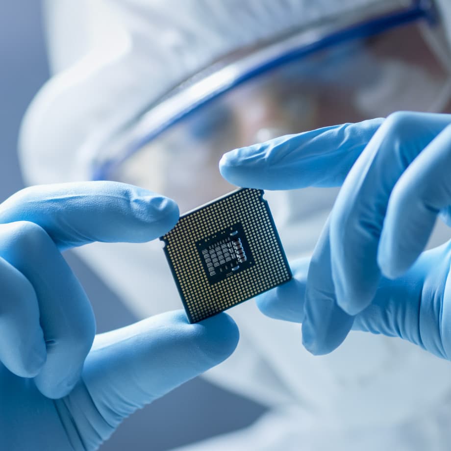 OSAT-partners Gloved hands holding a semiconductor chip in a cleanroom