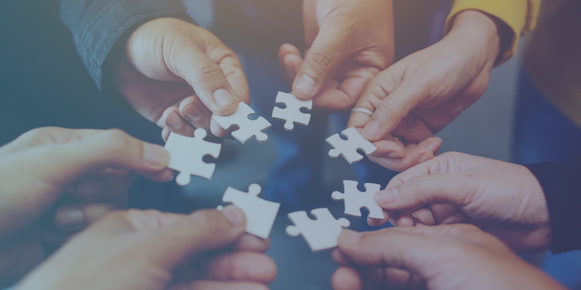 Our-partners Hands fitting together white puzzle pieces, symbolizing partnership and collaboration