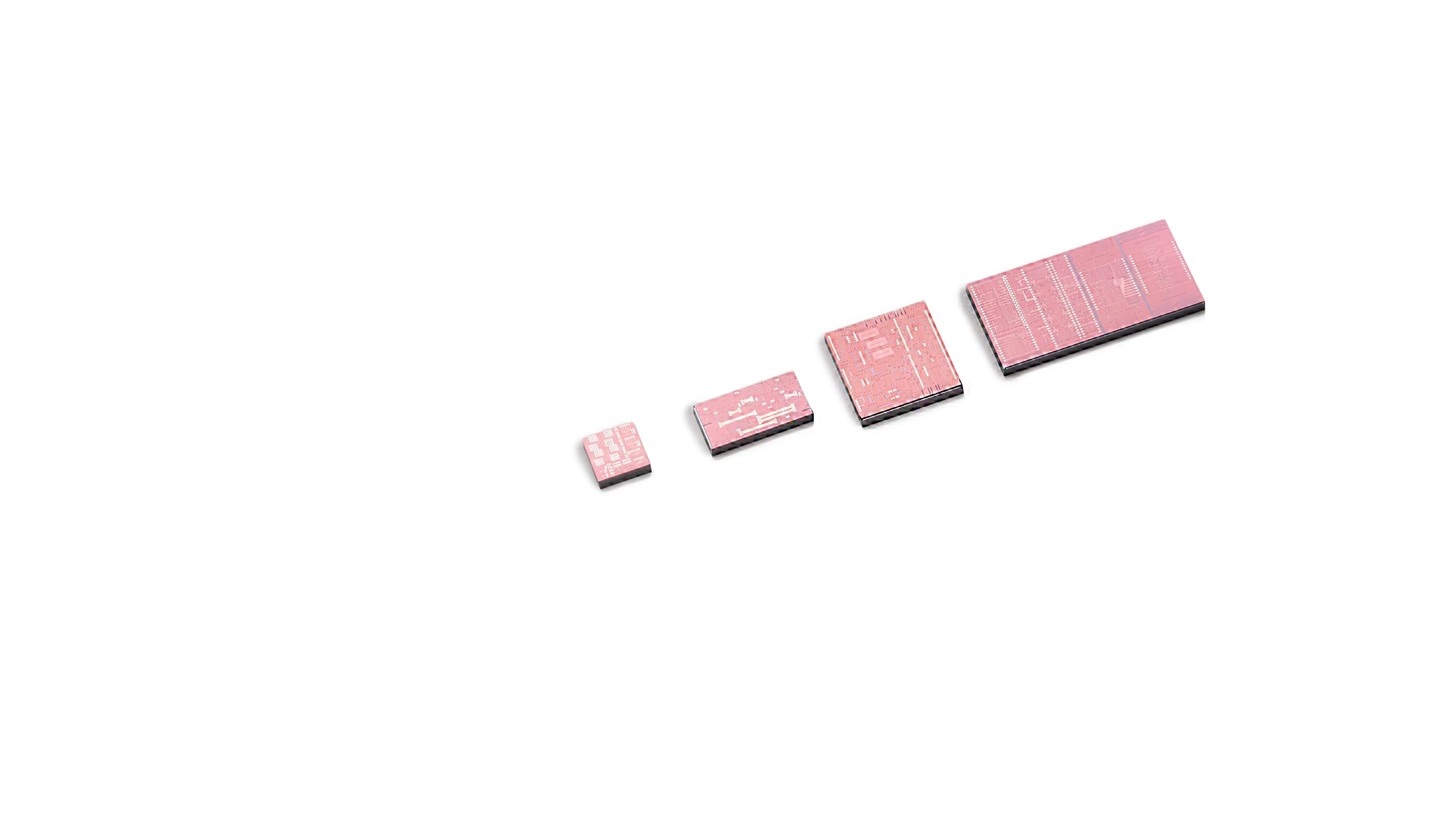 PIC%20manufacturing Four pink photonic chip dies arranged by size on a white background