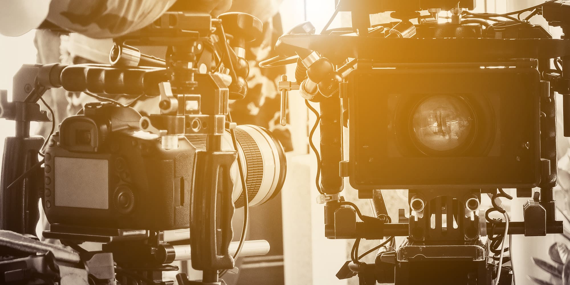 06_HR_tvs_1 Close-up of two professional video cameras filming in warm light