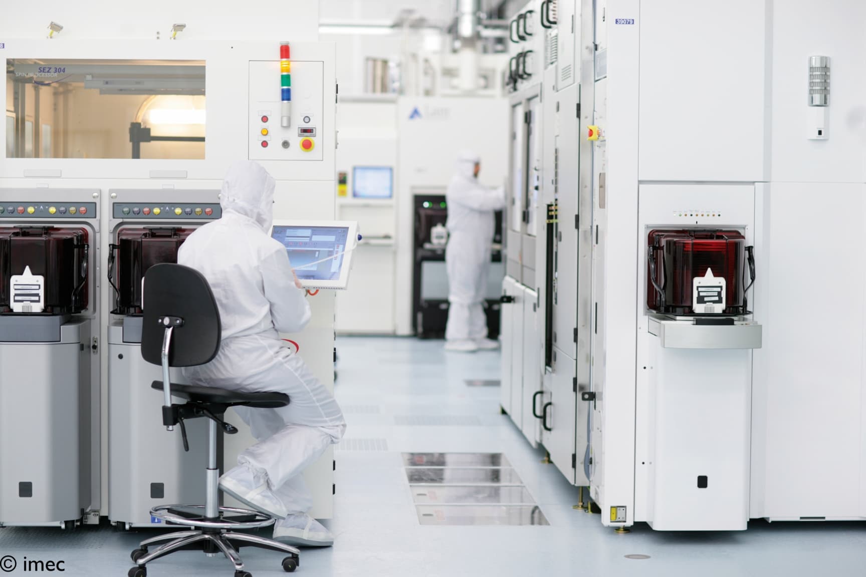 064-A-look-inside-imec%26%2339%3Bs-300mm-cleanroom-2022_maxWidth_2048_maxHeight_1152_ppi_72_quality_100_embedMetadata_true_contentETag_6 Researchers in a cleanroom operate semiconductor equipment in imec’s 300 mm fabrication area.