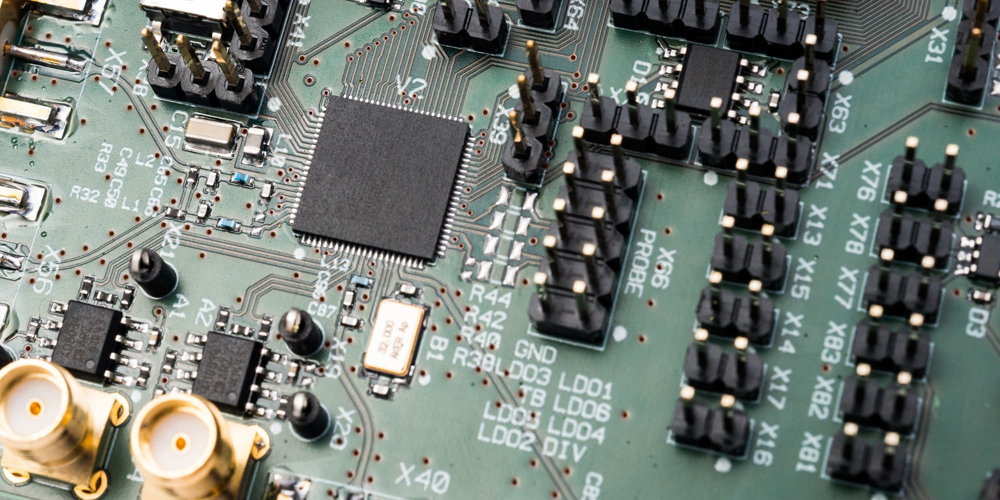08-IoT-Sensors_1 Close-up of a circuit board with a central chip and multiple sensor connectors