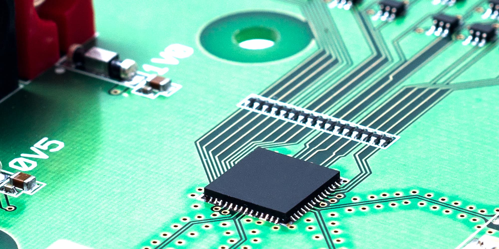 10-wireless_1 Close-up of a green circuit board with a black chip and fine signal traces.