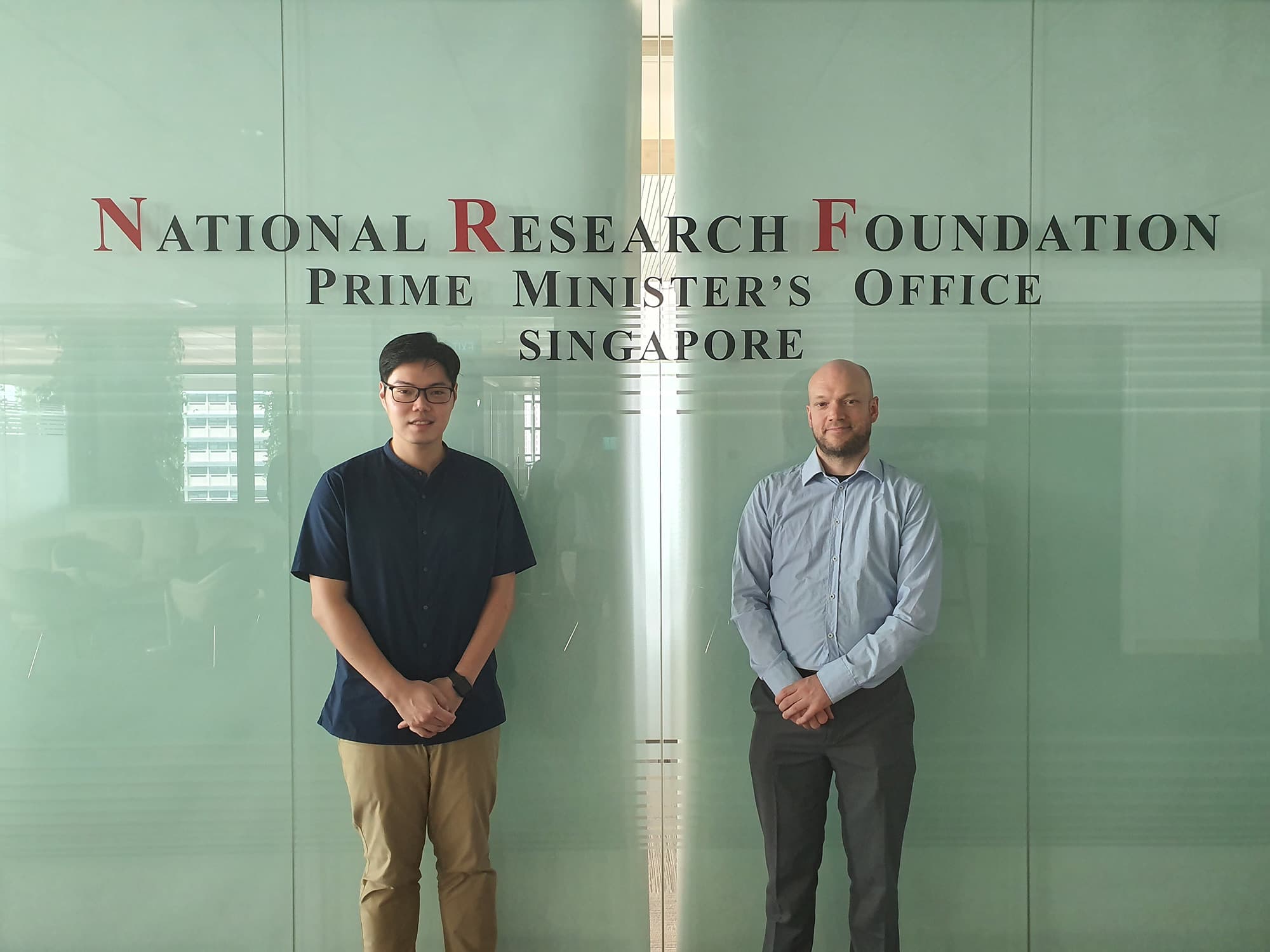 2019091203413_1 Two men standing in front of the National Research Foundation, Prime Minister’s Office Singapore sign