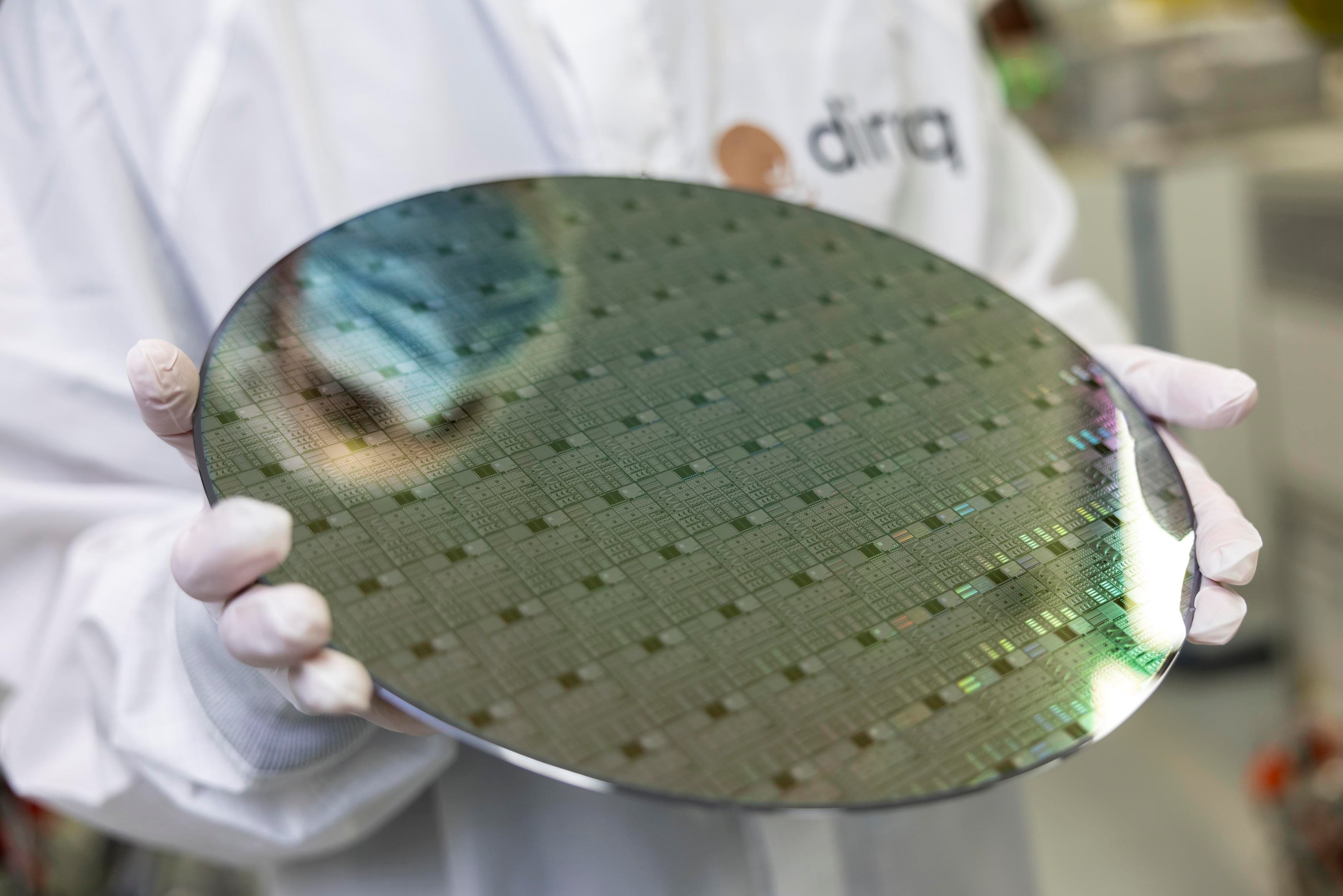 20250131_Diraq_SCREENRES_044_header Gloved researcher holding a large semiconductor wafer in a cleanroom