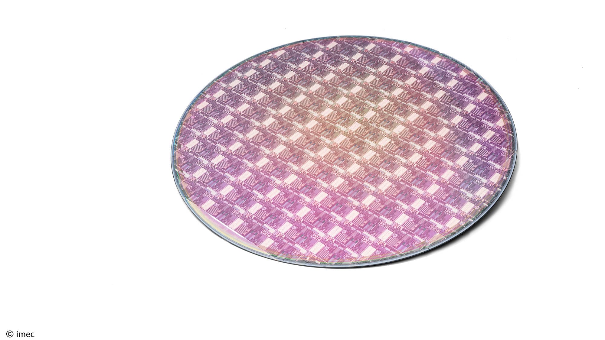 206-Wafer-processed-on-SiPho-platform001 A 300mm semiconductor wafer with a patterned chip layout on a white background.