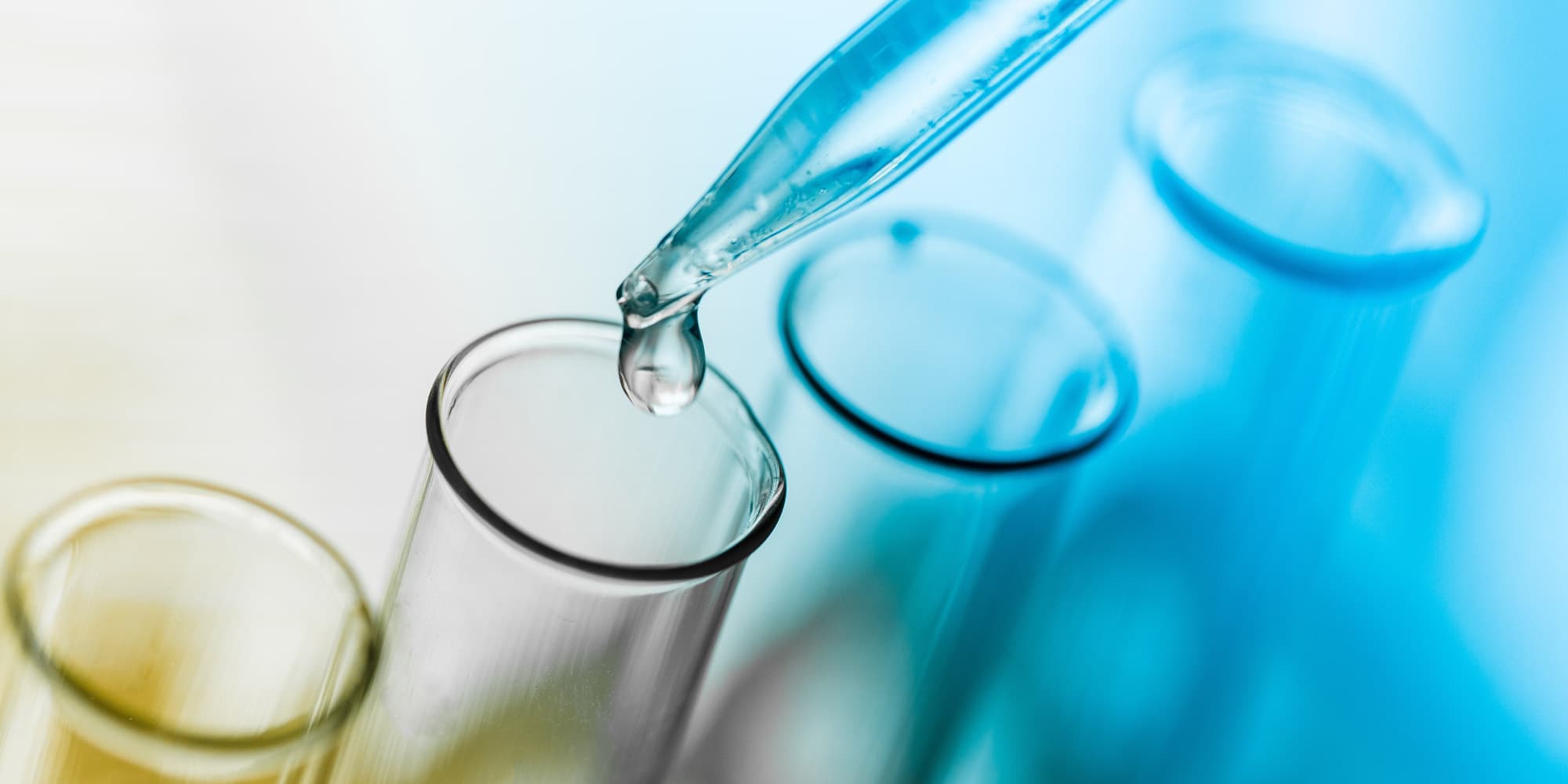 3.-A-summer-of-science-abroad_1 Pipette dispensing a droplet into a glass test tube among other test tubes in a lab