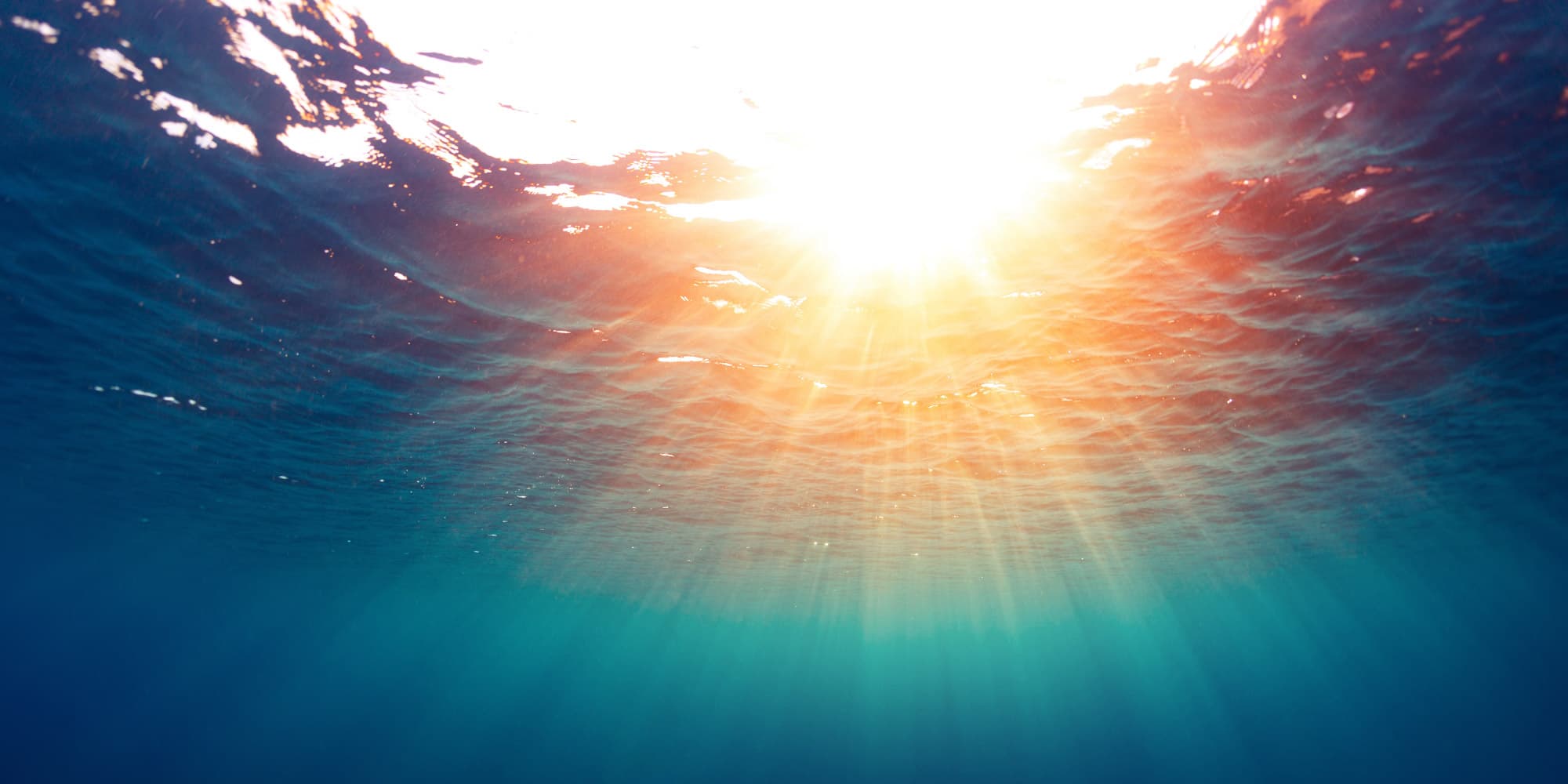 3.-zonnepanelen_1 Sunlight streaming through rippling water seen from below the surface