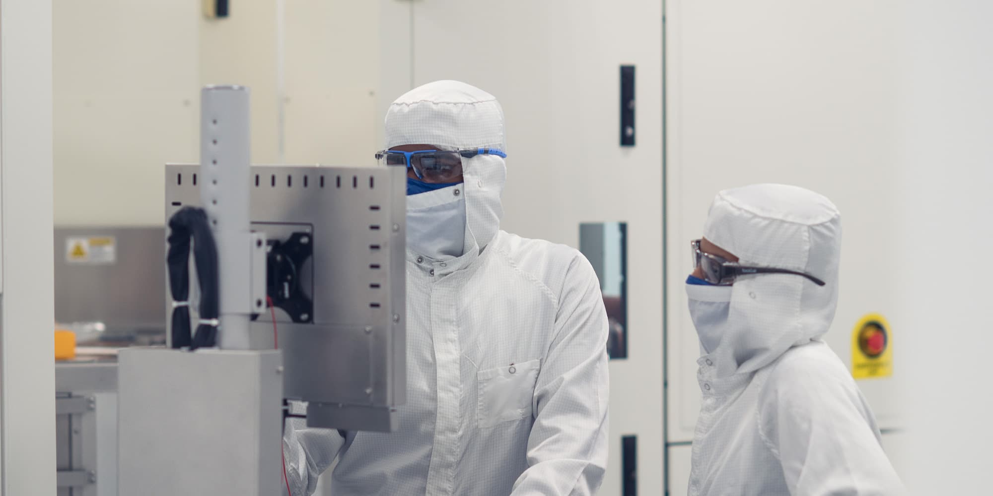 3D-integration Two cleanroom technicians inspect semiconductor equipment in a white lab