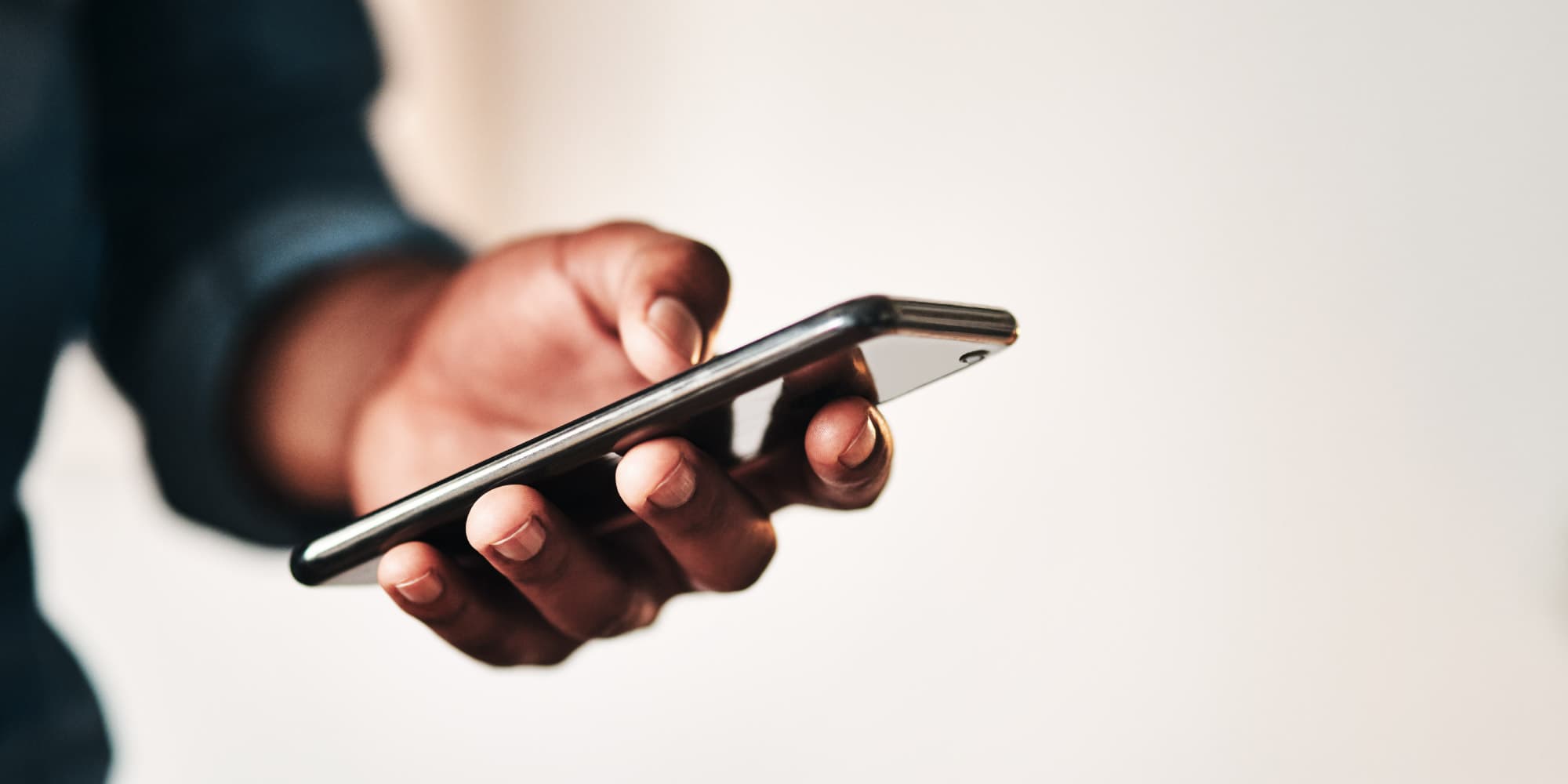 5G-netwerken-zullen-aan-de-stralingsnormen-van-de-Wereldgezondheidsorganisatie-moeten-voldoen Hand die een smartphone vasthoudt