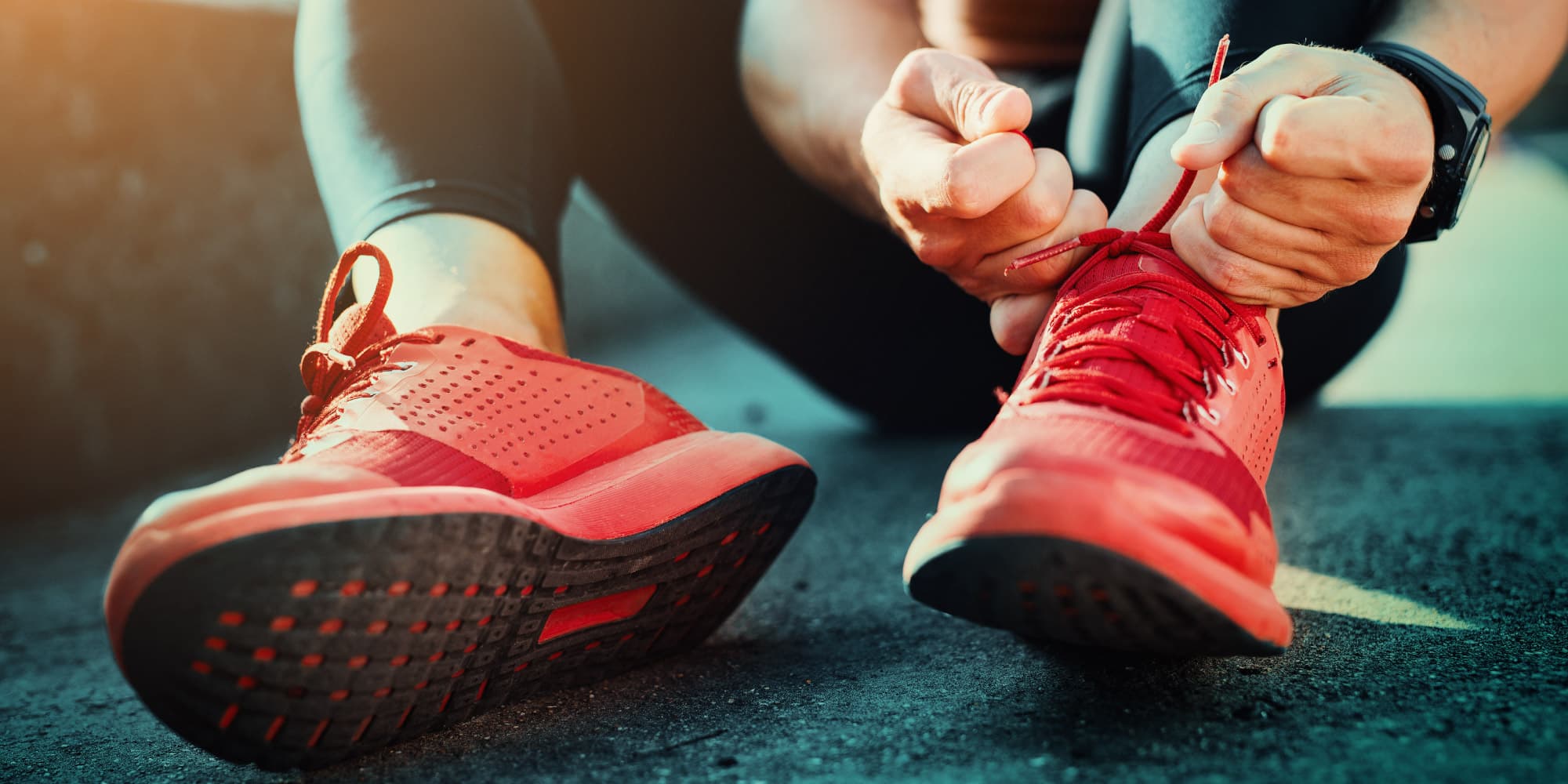 7.-a-smart-shoe-for-sportsmen-and-diabetics_1 Runner tying the laces of a red athletic shoe with a wearable sensor on the ankle