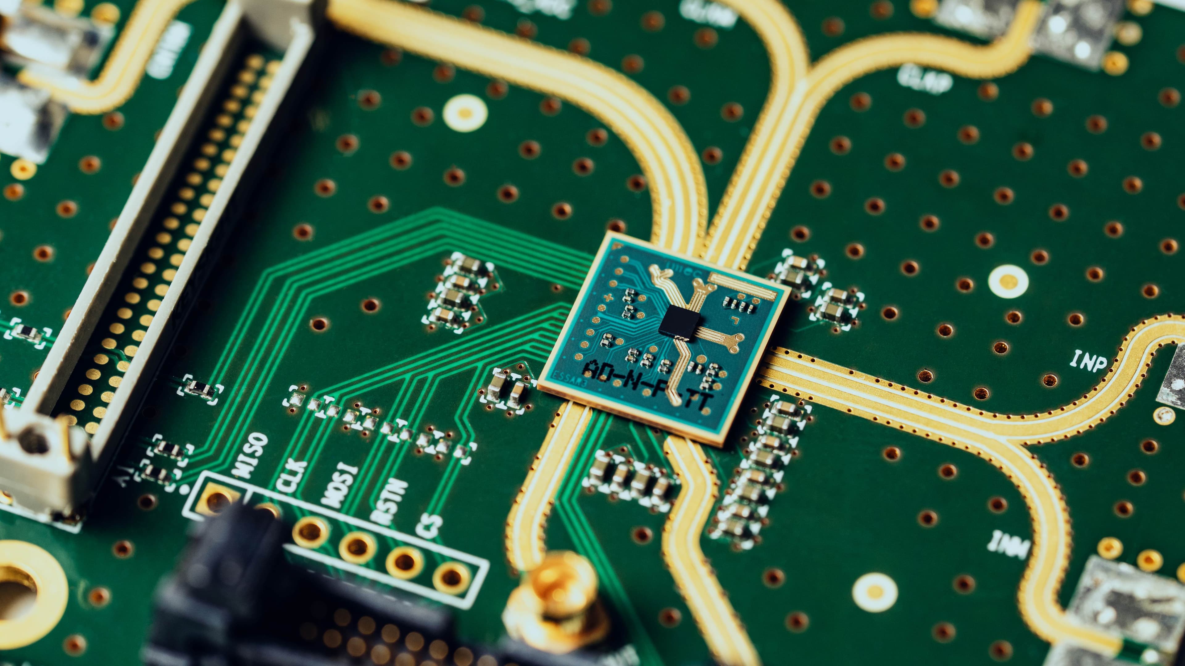 Close-up of microchip on circuit board with gold traces Close-up of a microchip mounted on a circuit board with gold traces and connectors