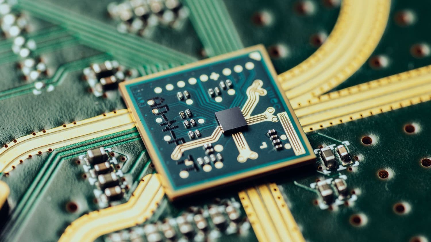 Close-up of chip on circuit board with gold traces Close-up of a chip mounted on a circuit board with gold traces and tiny components.
