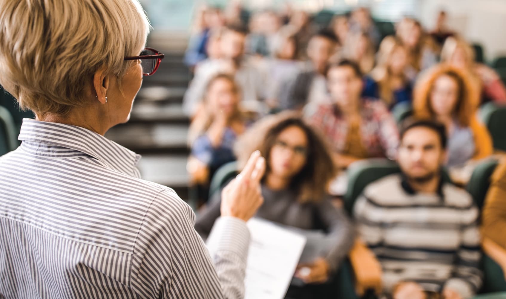 academic-excellence_1 Speaker addressing an audience in a lecture hall