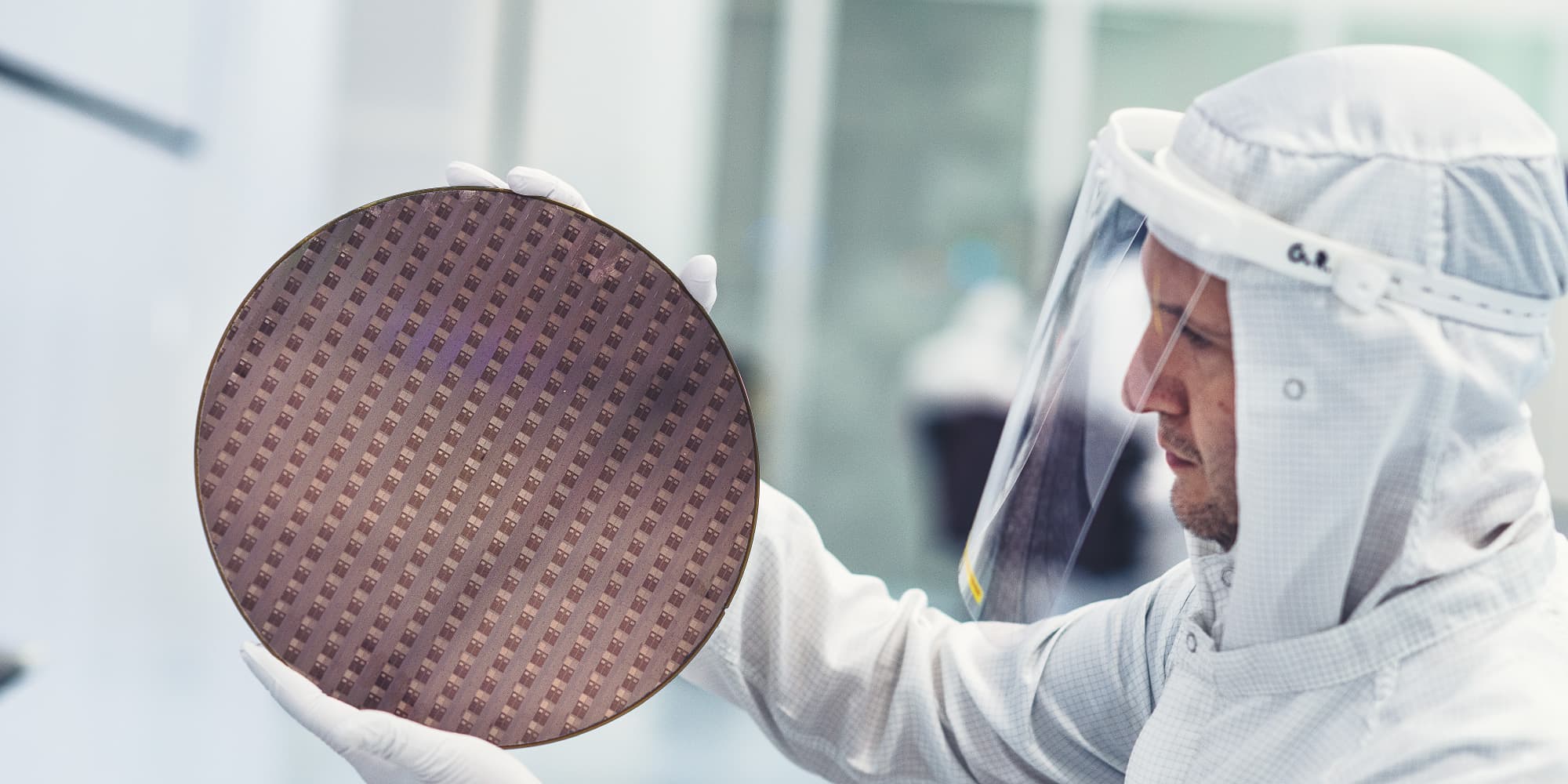 Active-memory Cleanroom researcher holding a semiconductor wafer for inspection