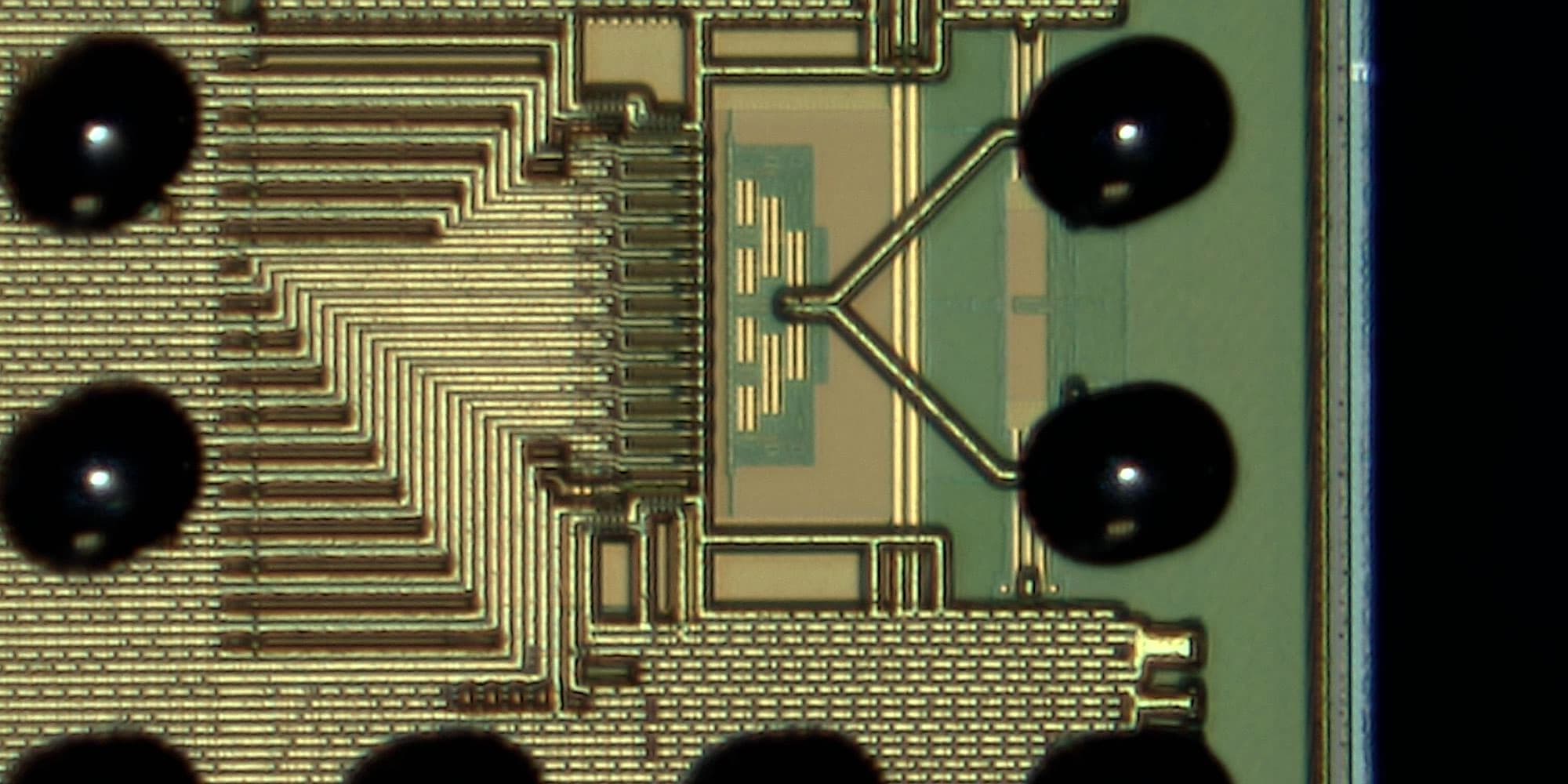 advanced-RF Close-up of a microchip die with dense metal traces and bonding pads