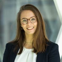 Ann%20Vankerckhoven Portrait of Ann Vankerckhoven smiling in glasses and a dark blazer