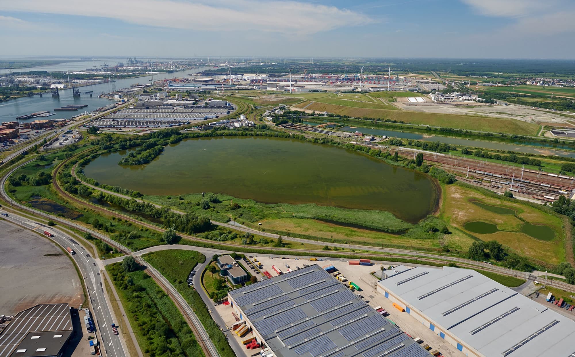 AntwerpseHaven Aerial view of the Port of Antwerp with docks, industrial buildings, roads and green spaces