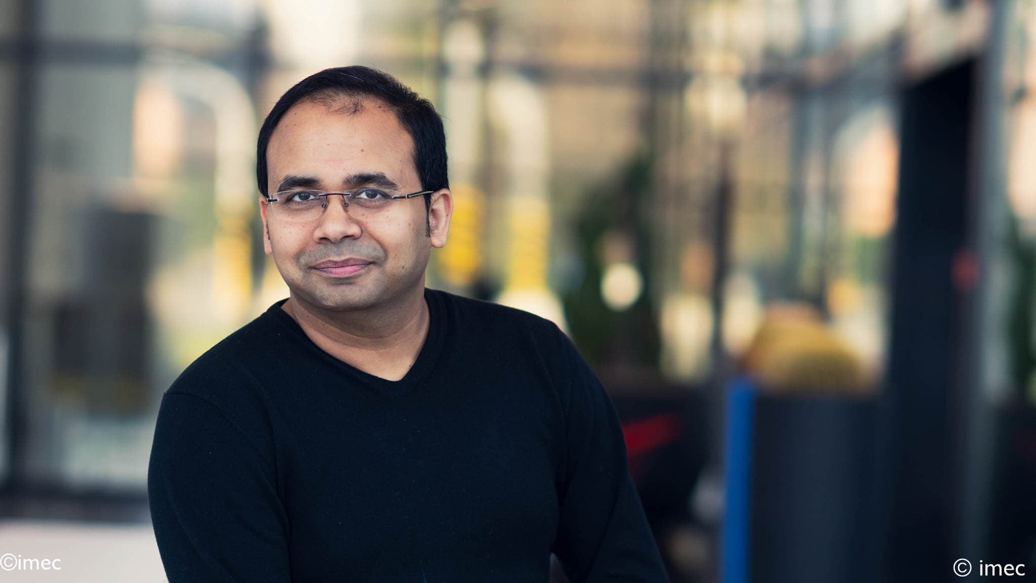 Arindam%20Mallik Portrait of Arindam Mallik in a black shirt against a blurred imec background