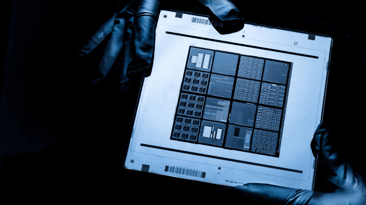 ASIC-example Gloved hands holding a printed chip layout with multiple die blocks