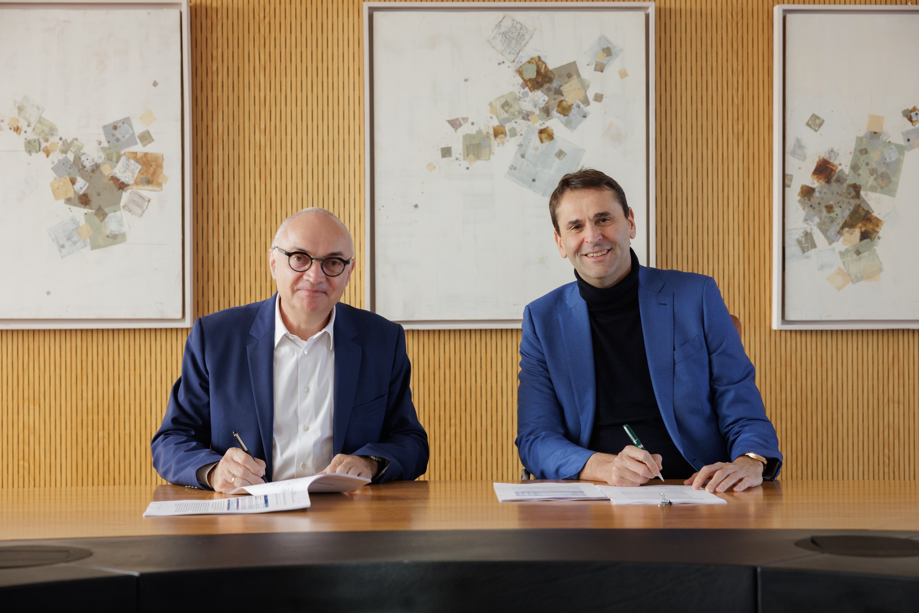 ASML_Signing_Imec_March_2025_001 Two men sign documents at a table during a partnership agreement ceremony.