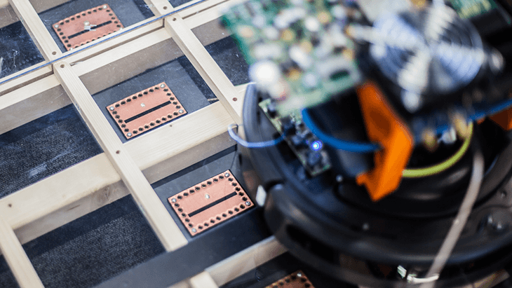 ATTO Research setup with a circuit board module over a grid of chip-like copper pads