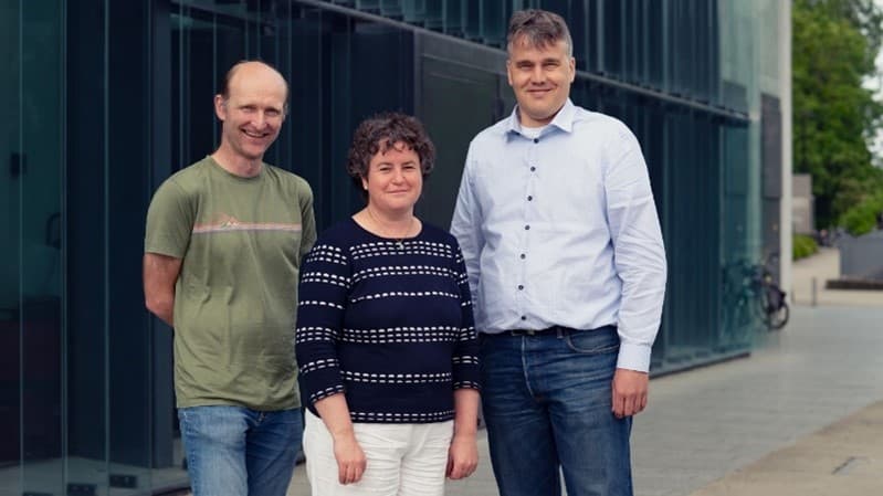 Authors-CFET Three imec researchers standing outdoors by a glass building