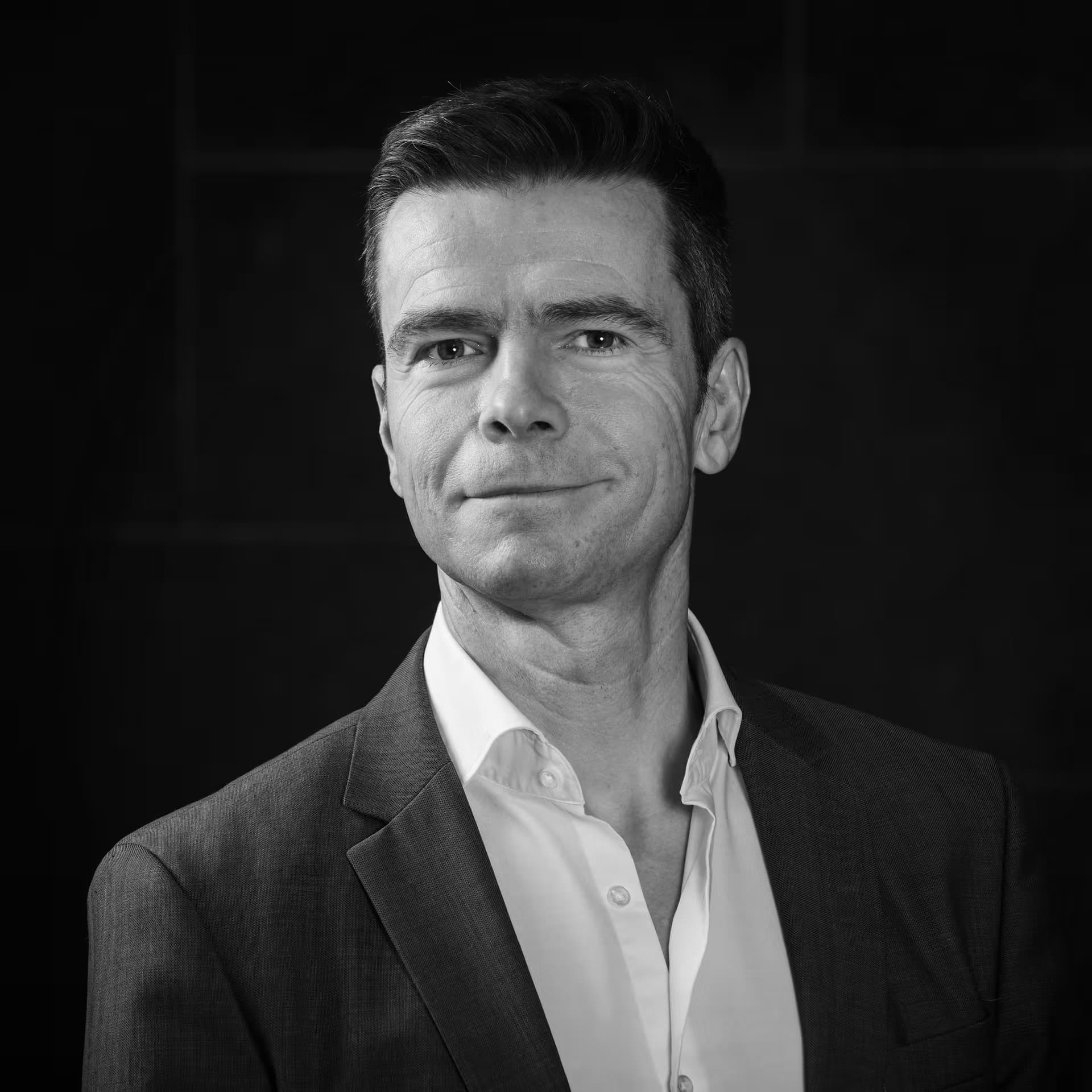 Bert%20Gyselinckx Black-and-white headshot of Bert Gyselinckx in a suit and open-collar shirt