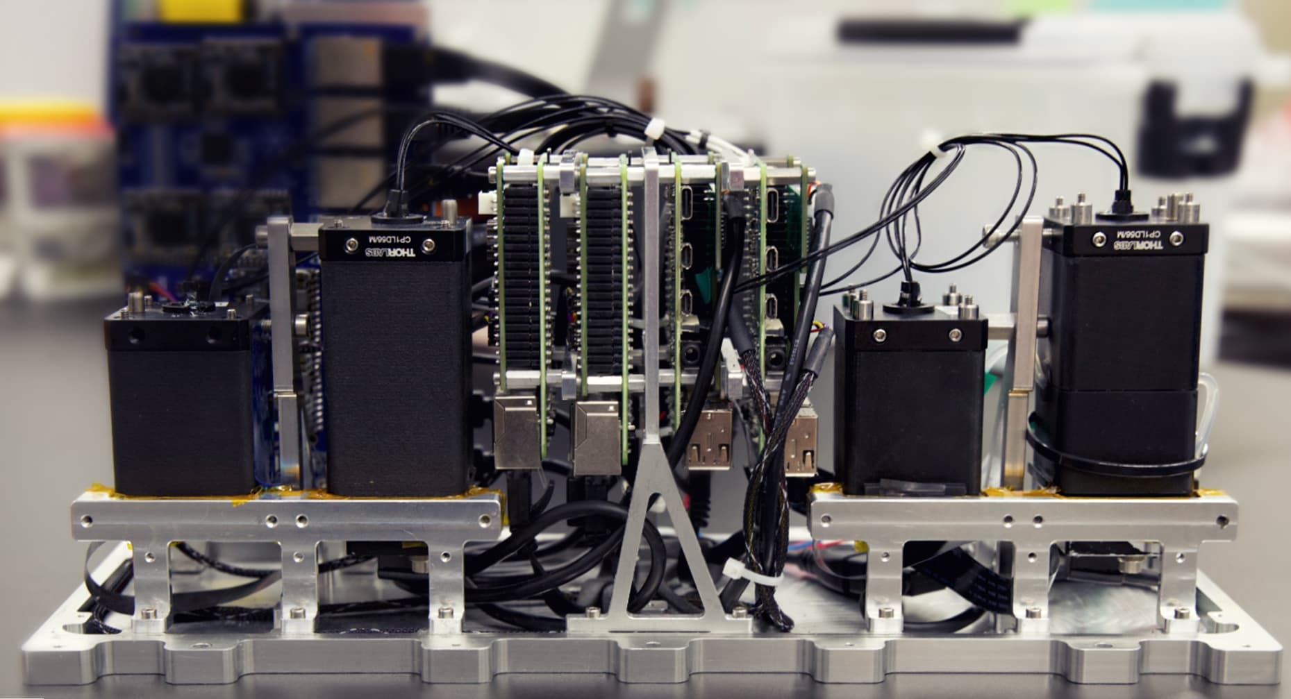 BlueOrigin_NS_LFI_blurred_1MB Automated lens-free imaging microscope setup with four modules, cables, and metal mounts in a lab