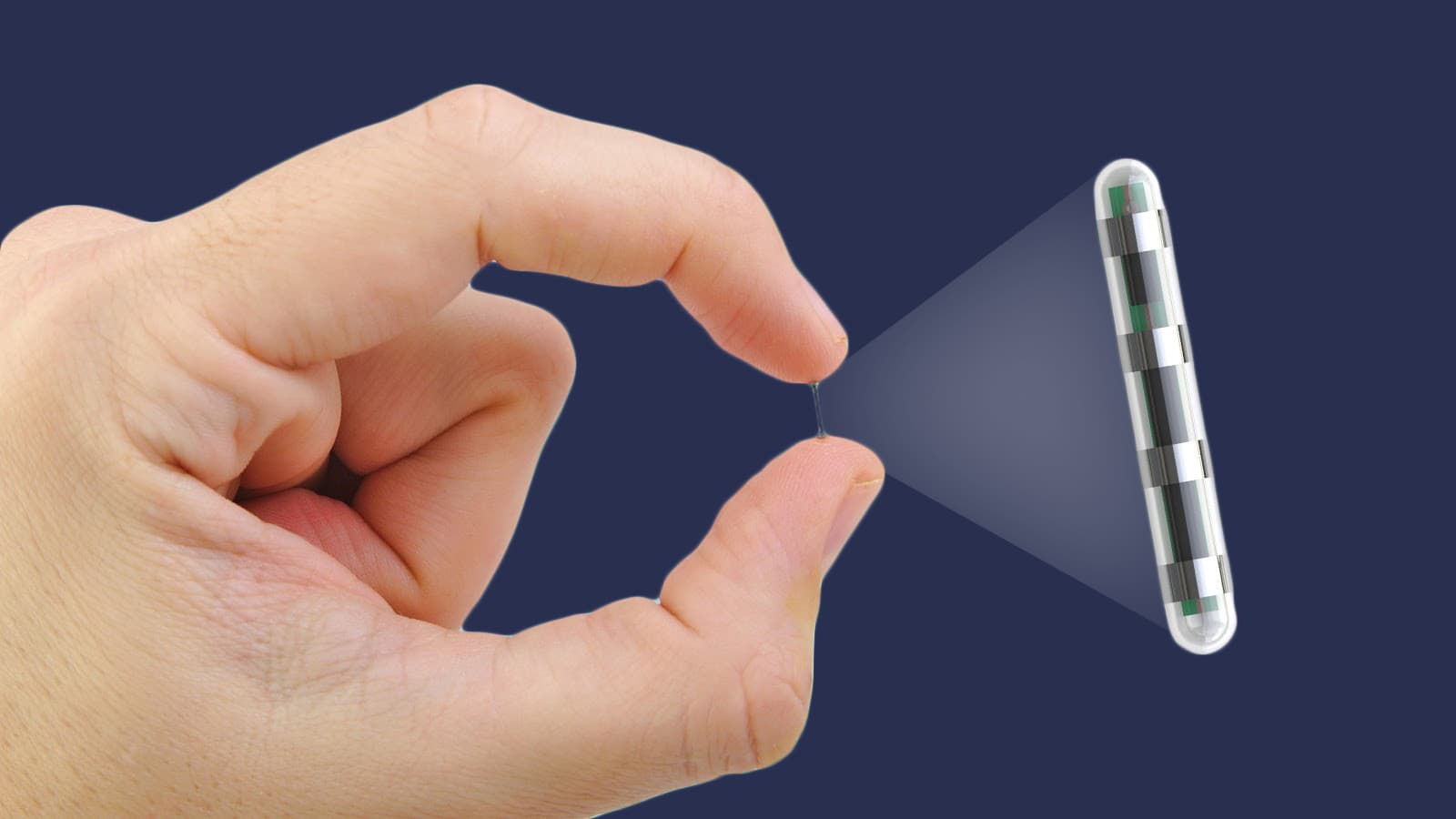 capri-medical Hand holding a tiny injectable implant shown beside a fingertip for scale