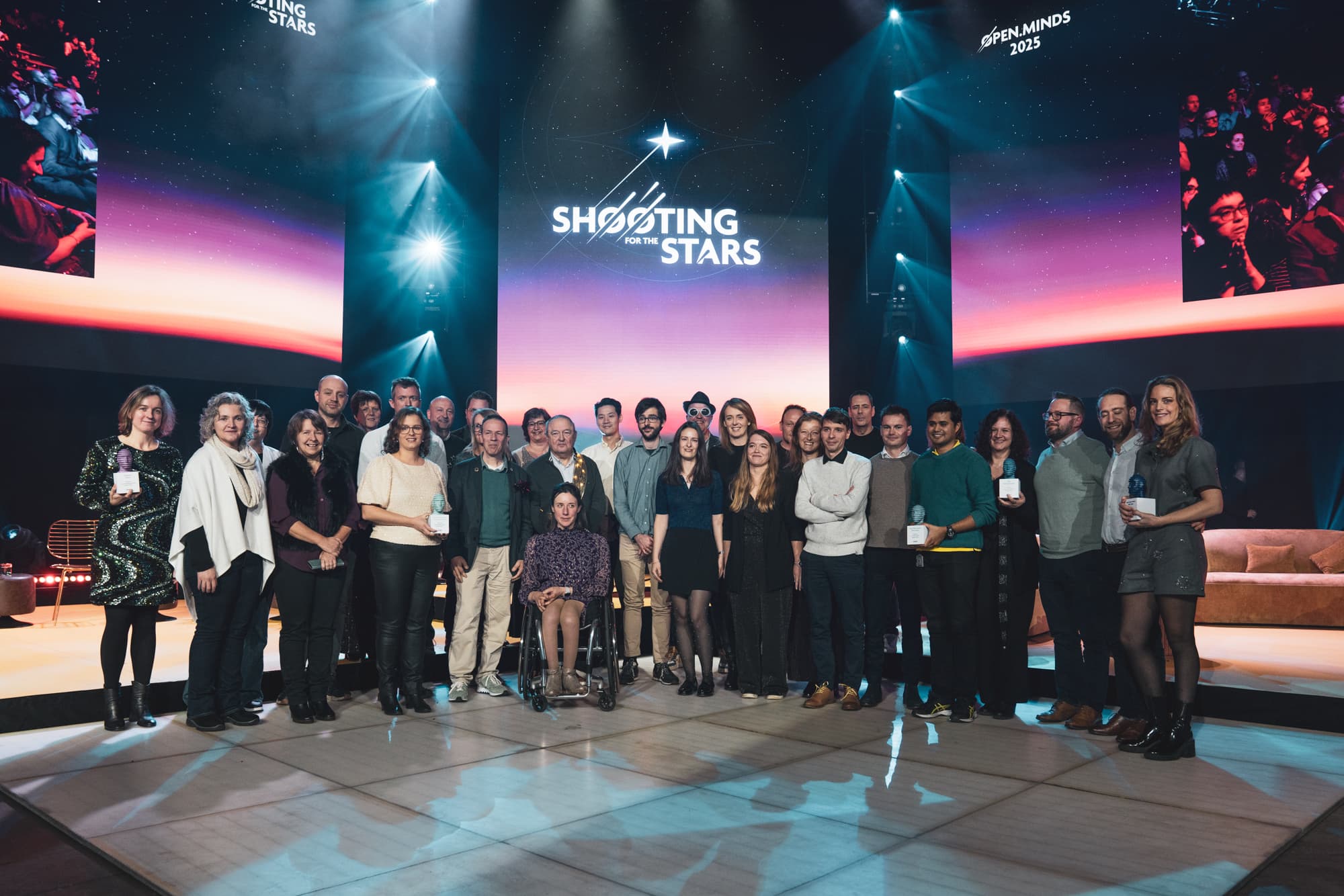Carroussel%205 Group of people on stage at an Open Minds 2025 event holding awards