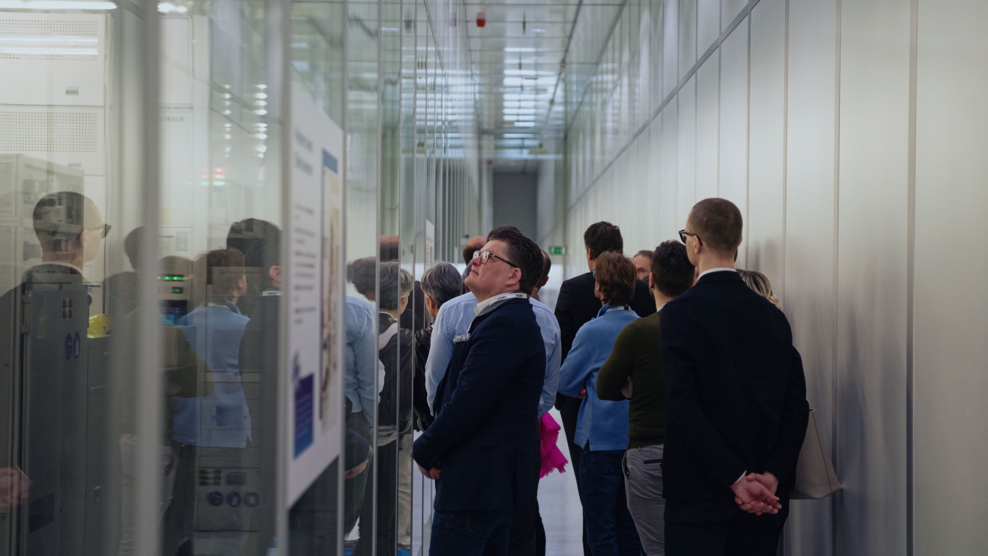 Carroussel%206 Group of visitors touring a cleanroom corridor with glass walls