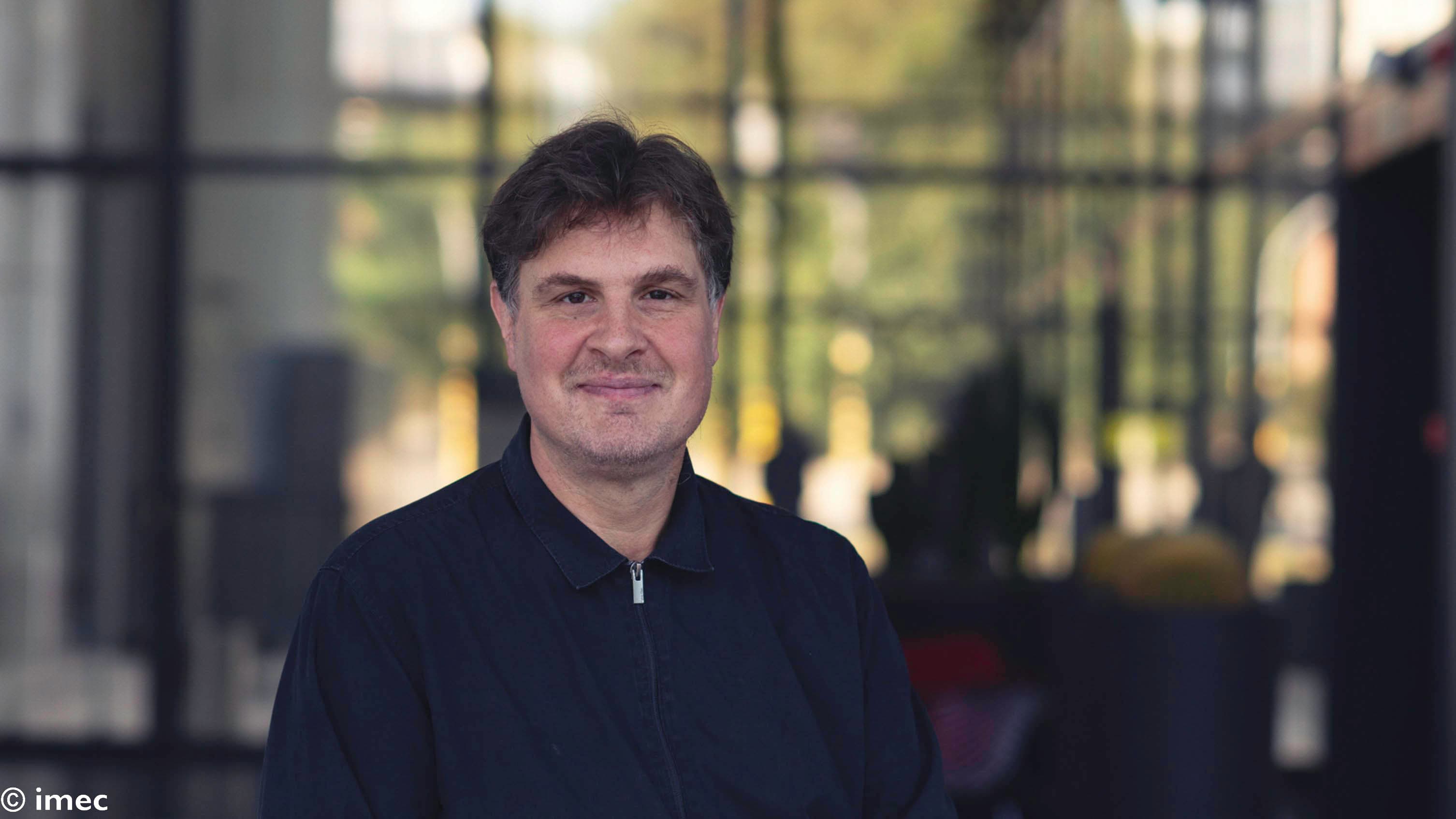 Christoph%20Adelmann Christoph Adelmann smiling in a blurred indoor setting