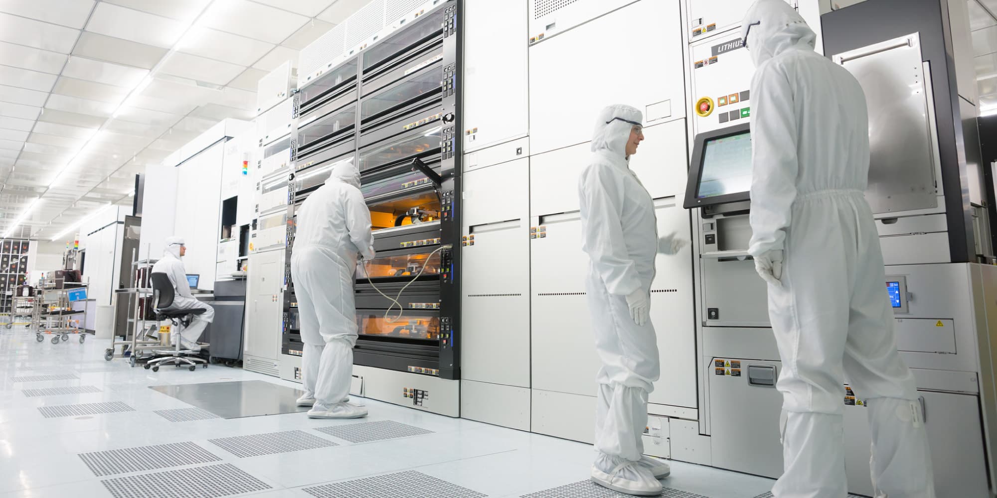 cleanroom Researchers in white cleanroom suits operating semiconductor lithography equipment in a cleanroom