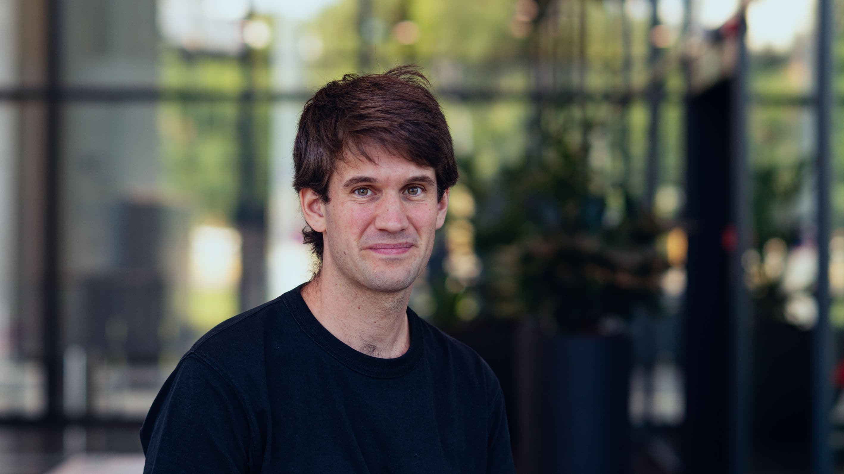 Clement%20Godfrin Portrait of imec device engineer Clement Godfrin outdoors in front of a glass building