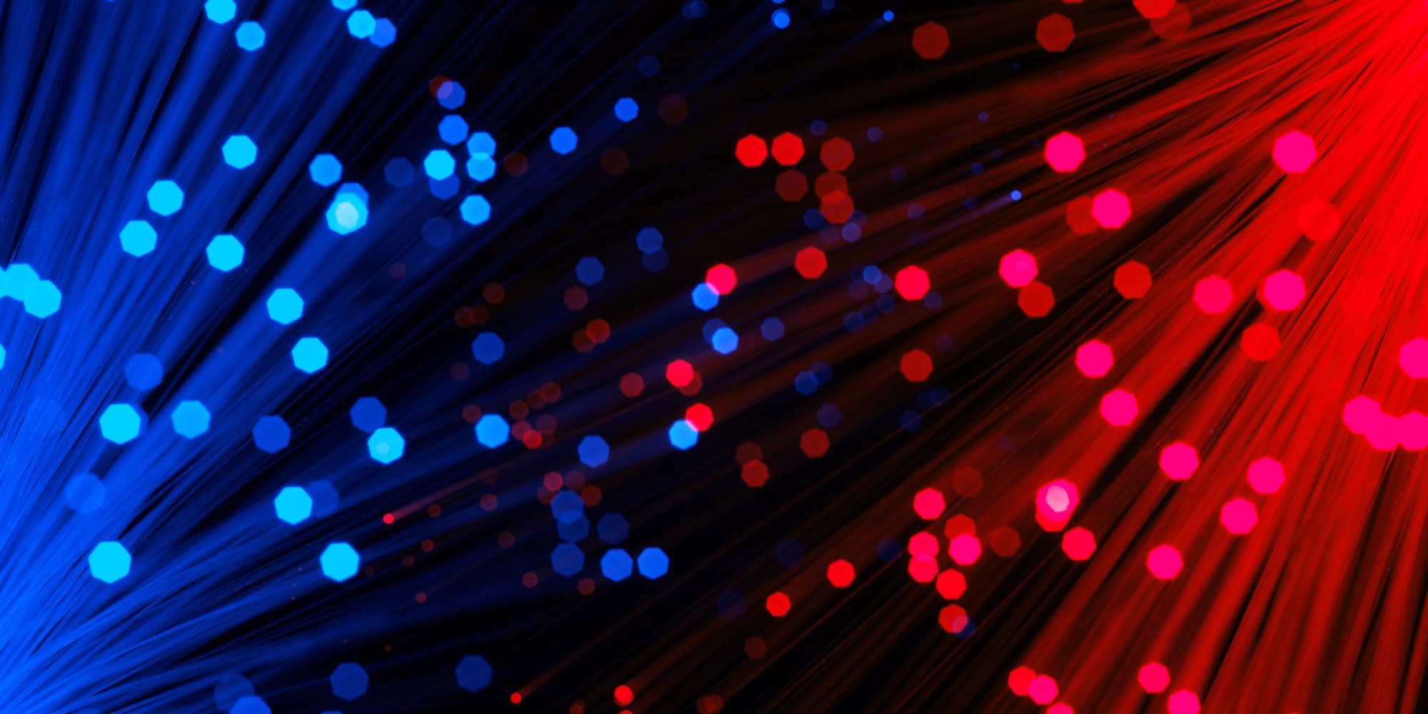 collaboration-johnson-%26-johnson Abstract blue and red fiber-optic light strands with glowing bokeh dots on a dark background
