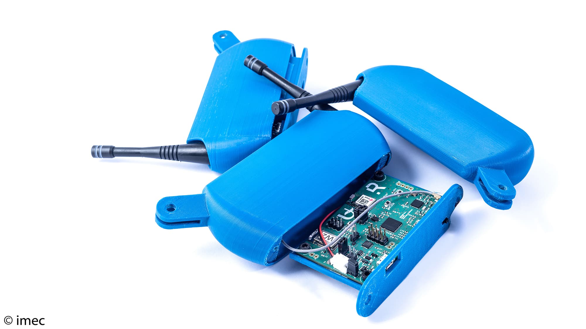Conamo004 Blauwe sensormodules met antennes en een blootliggende printplaat op een witte achtergrond