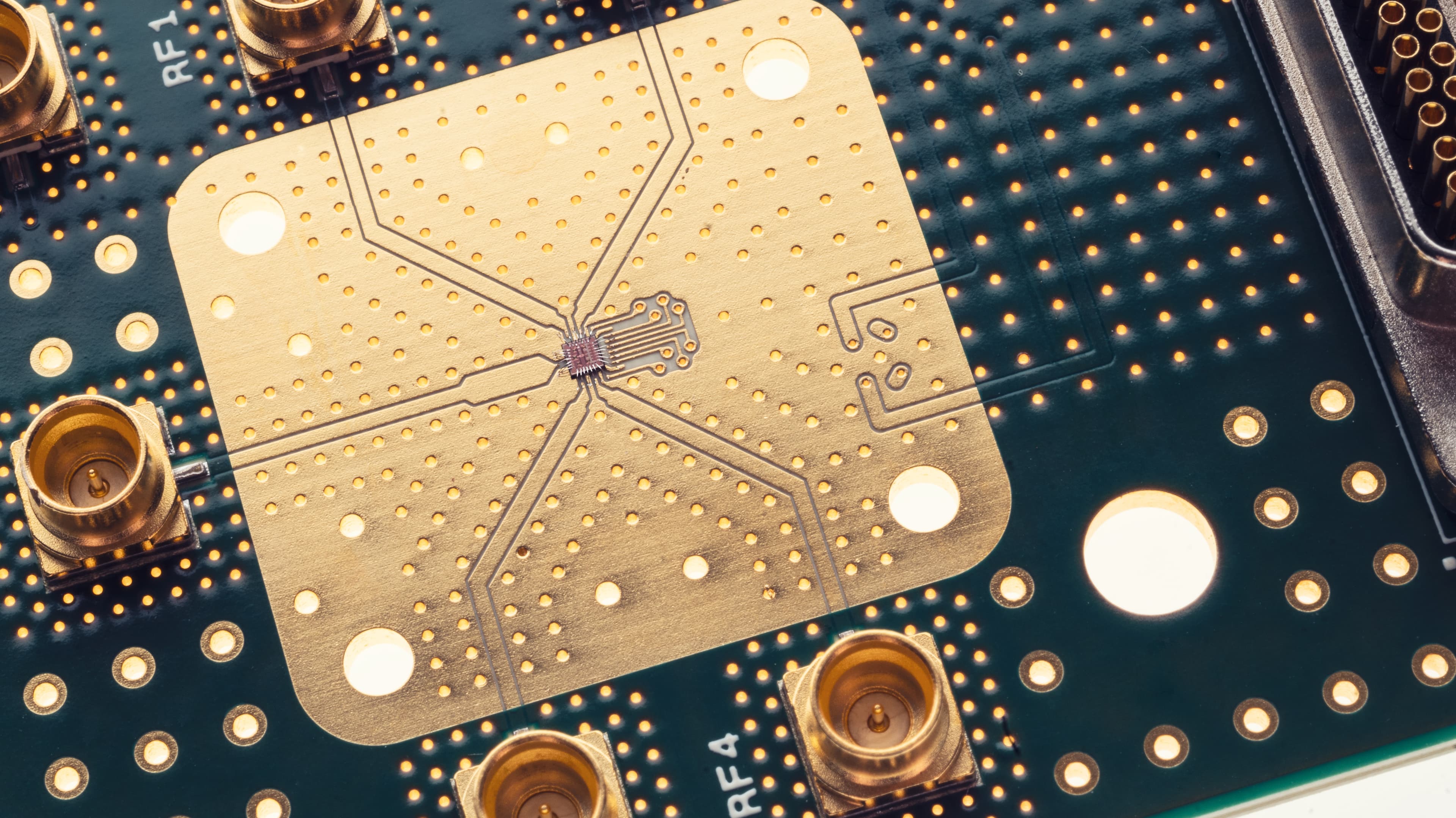 Cryo%20CMOS%20physical%20qubits Close-up of a cryogenic quantum chip on a circuit board with gold contacts and wiring