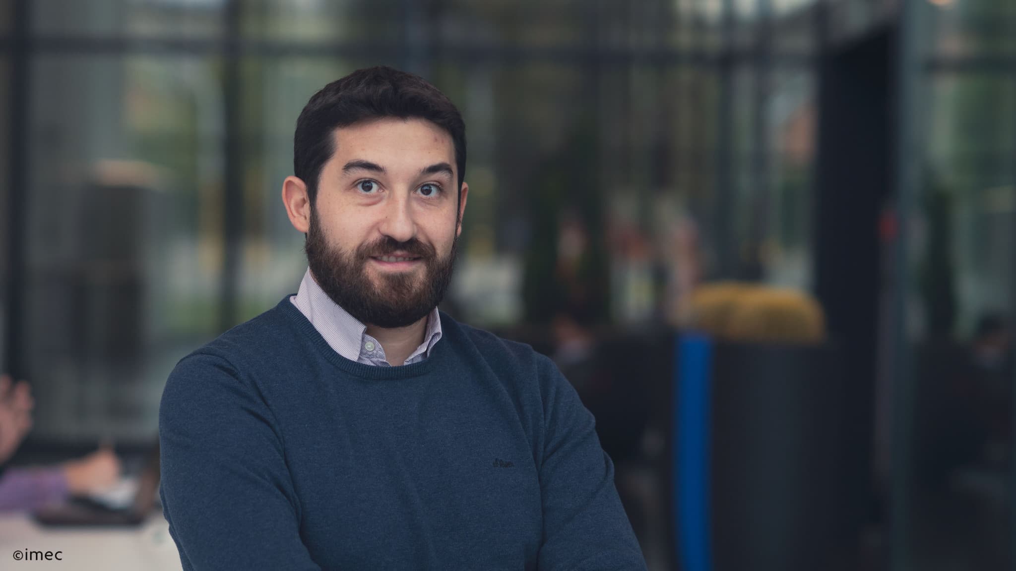 Daniele%20Garbin Portrait of Daniele Garbin standing indoors at imec with a blurred lab-like background
