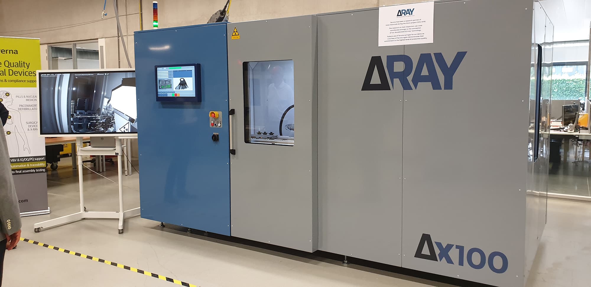 deltaray_photo Large ARAY AX100 inspection machine in a lab, with a monitor showing the internal system view.